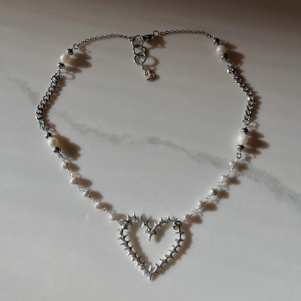 A necklace part of the gilgo collection with a thorny heart.