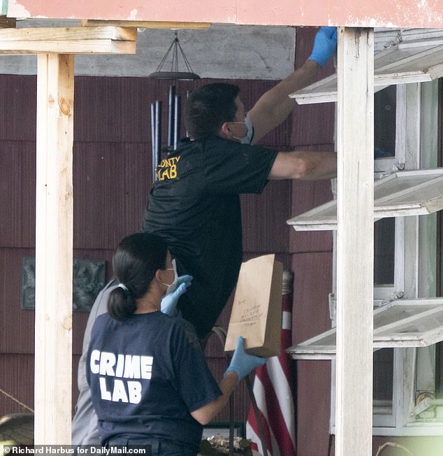 Two members of the crime lab are pictured taking paint chip samples from Heuermann's porch