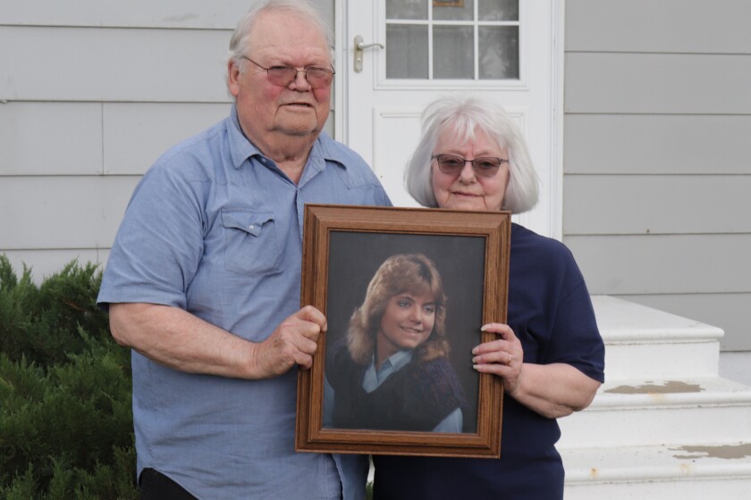 Wes and Linda Julson stand on the lawn in front of their house in Center, North Dakota, and hold a fframed photo of their missing daughter, Michelle (Shelly) Julson