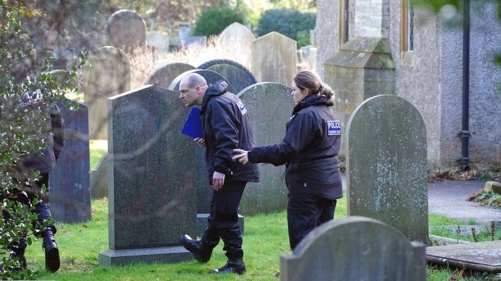 Police searching a graveyard