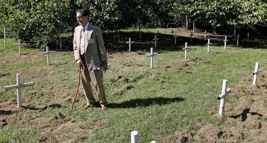 Dick Colon, one of the White House Boys, walks through grave sites near the Dozier School for Boys in Marianna, FL. 