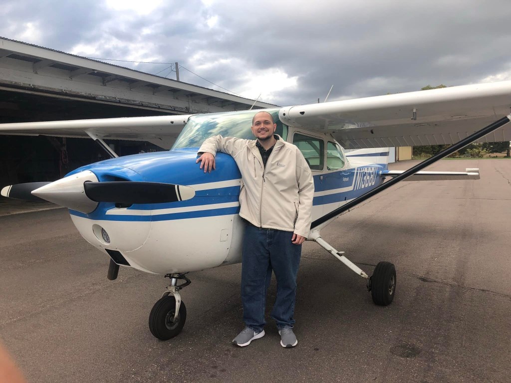 Photo of Fravel posing in front of a small plane.