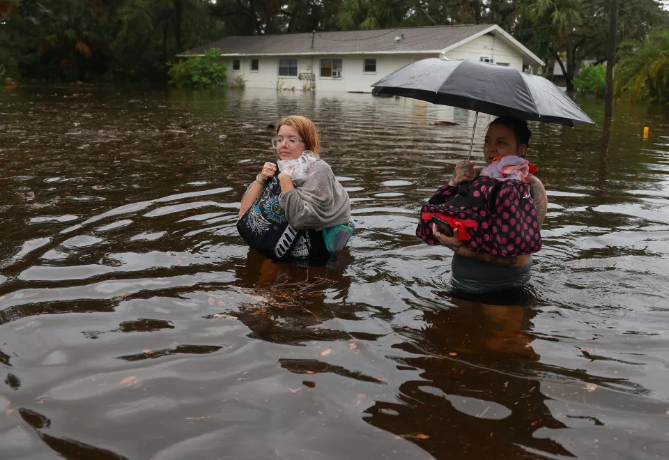 Makatla Ritchter, left, and her mother, Keiphra Line,  wade through flood waters after having to evacuate their home during Hurricane Idalia on August 30, 2023, in Tarpon Springs, Florida.  / Credit: Getty Images