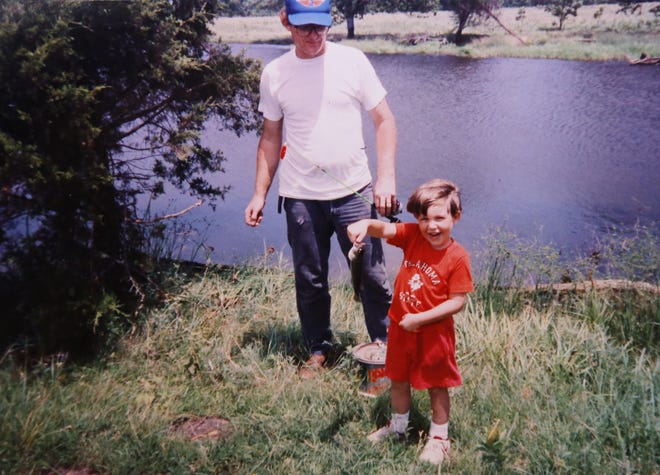 A family photo depicts Michael Anthony Hughes fishing with his foster dad, Ernest Bean.